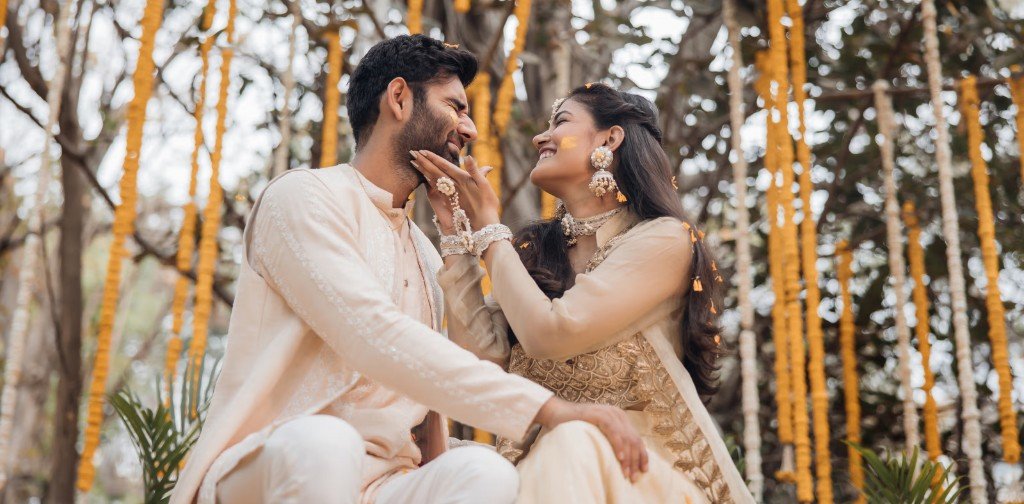 Couple celebrating during a traditional Haldi ceremony with marigold décor